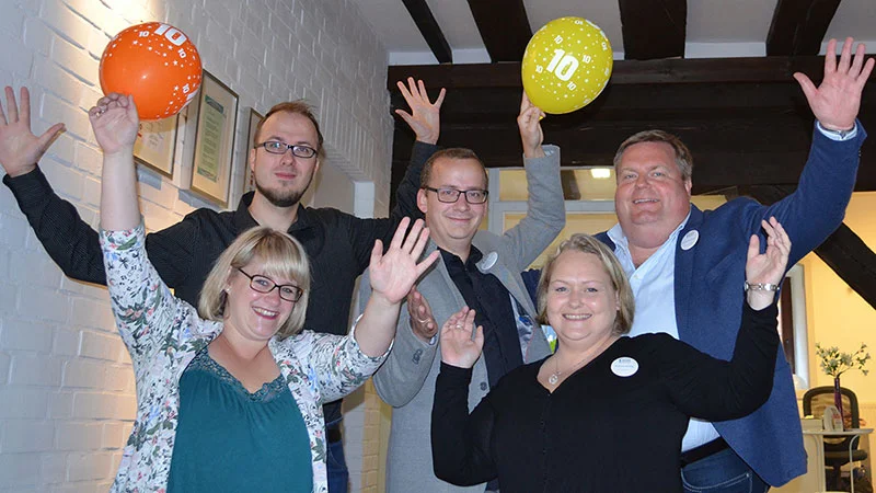 eine Gruppe von Menschen, die Ballons in der Luft halten und sich freuen